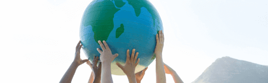 mãos de criança segurando uma bola que representa o planeta terra